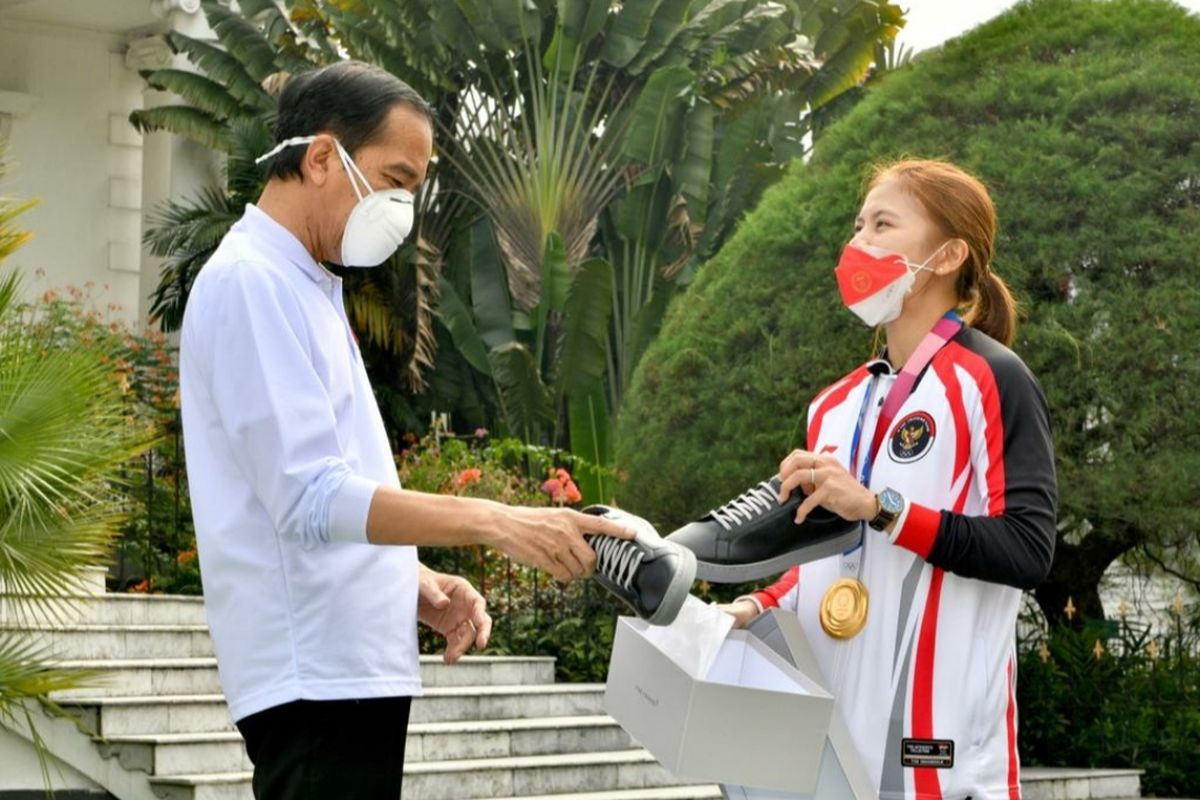 Presiden Joko Widodo melihat sepatu produk UMKM milik Greysia Polii usai menerima para atlet kontingen Indonesia untuk Olimpiade Tokyo 2020 di Istana Kepresidenan Bogor, Jumat (13/8/2021). 