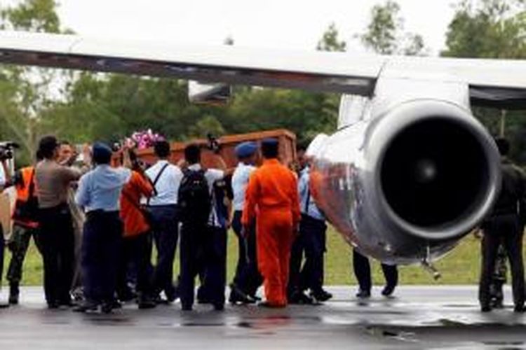 Petugas Basarnas membawa jenazah yang sudah dimasukan ke dalam peti dari Posko Utama Pecarian Pesawat AirAsia QZ8501, Lanud Iskandar, Pangkalan Bun, Kalteng, Rabu (31/12/2014), menuju Surabaya menggunakan pesawat TNI AU.