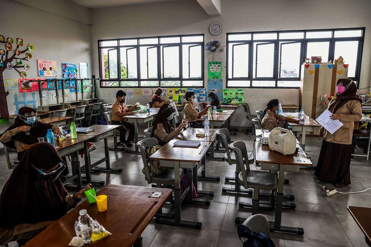 Guru memberikan materi pelajaran kepada murid saat uji coba pembelajaran tatap muka pada hari pertama di SDN 03 Palmerah, Jakarta Barat, Rabu (7/4/2021). Pembelajaran tatap muka (PTM) di wilayah PPKM level 3 Jawa-Bali masih mengacu Surat Keputusan Bersama (SKB) 4 Menteri tentang Panduan Penyelenggaraan Pembelajaran pada Masa Pandemi Covid-19 dengan menggelar PTM terbatas dengan jumlah peserta didik 50 persen dari kapasitas ruang kelas dan pembelajaran jarak jauh (PJJ).