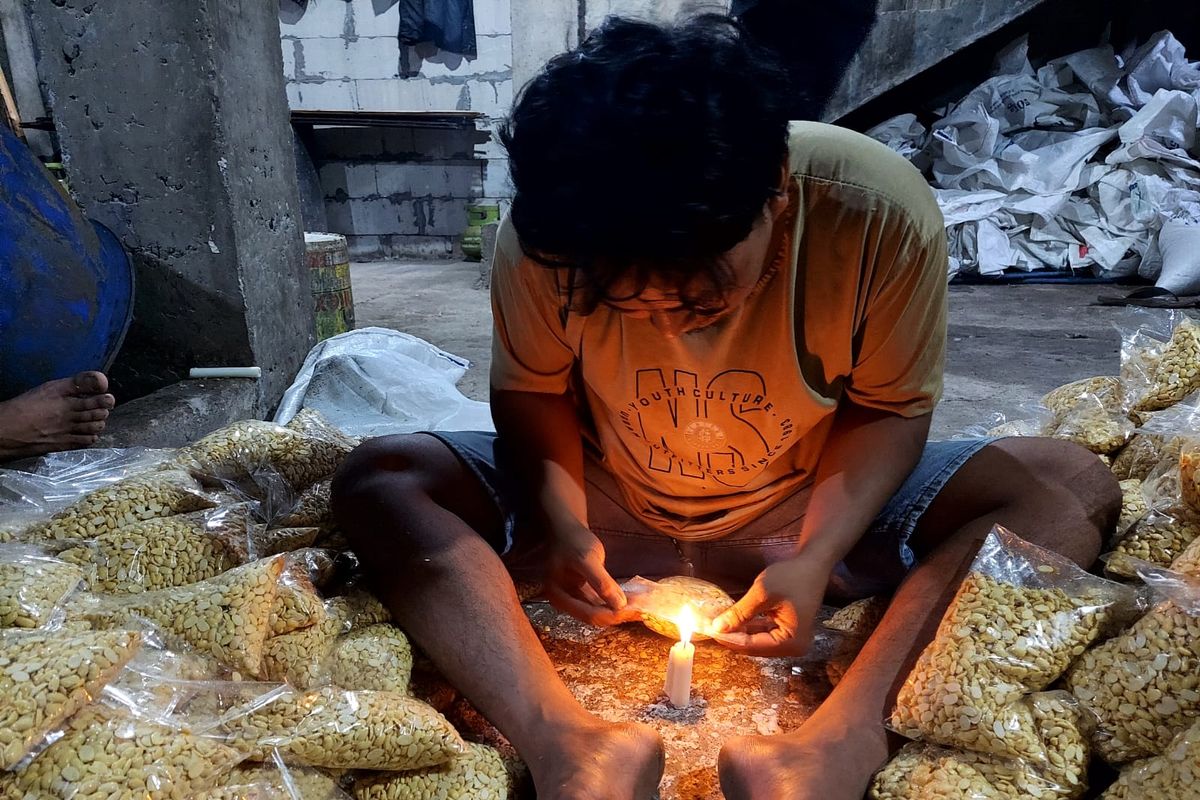 Seorang perajin tengah mengemas kedelai yang siap dibuat tempe