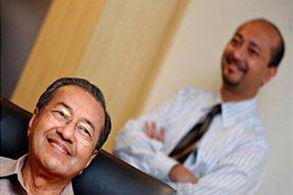Mahathir Mohammad (kiri) tersenyum saat menjawab pertanyaan dari sejumlah wartawan saat Mukhriz Mahathir yang berada di belakangnya memperhatikan berlangsungnya konferensi pers di Putrajaya, 8 Januari 2007.