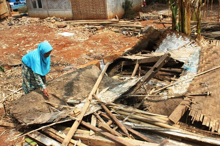 Eha Julaeha (75) tengah mengais barang perabotan miliknya di antara reruntuhan bangunan rumahnya di Kampung Nyalindung, RT 001/004 Desa Cipeuyeum, Kecamatan Haurwangi, Kabupaten Cianjur, Jawa Barat yang ambruk.