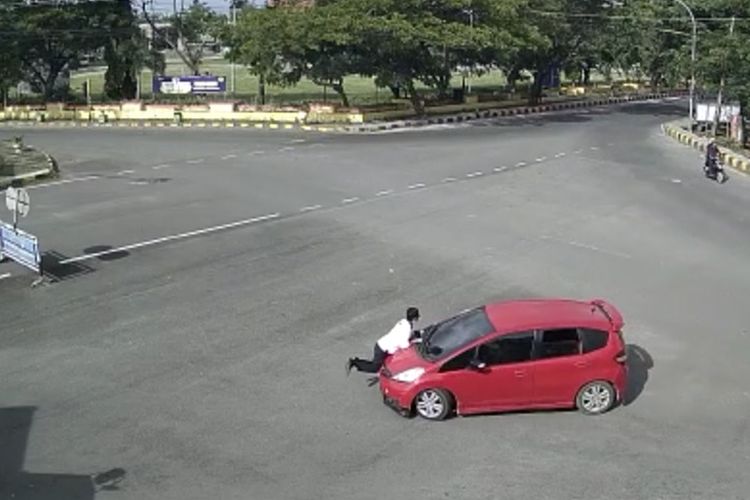 Tangkapan layar video aksi seorang perwira polisi di Kabupaten Jeneponto, Sulawesi Selatan, terekam CCTV berusaha menghadang aksi perampasan mobil hingga kritis setelah terseret sejauh 1 kilo meter. Kamis, (27/1/2022).