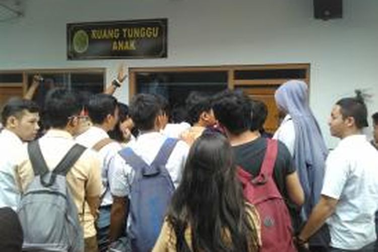 Teman-teman terdakwa sesama murid SMA 3 sedang menemui terdakwa dari balik kaca ruang tahanan anak gedung Pengadilan Negeri Jakarta Selatan, Rabu (13/8/2014). 