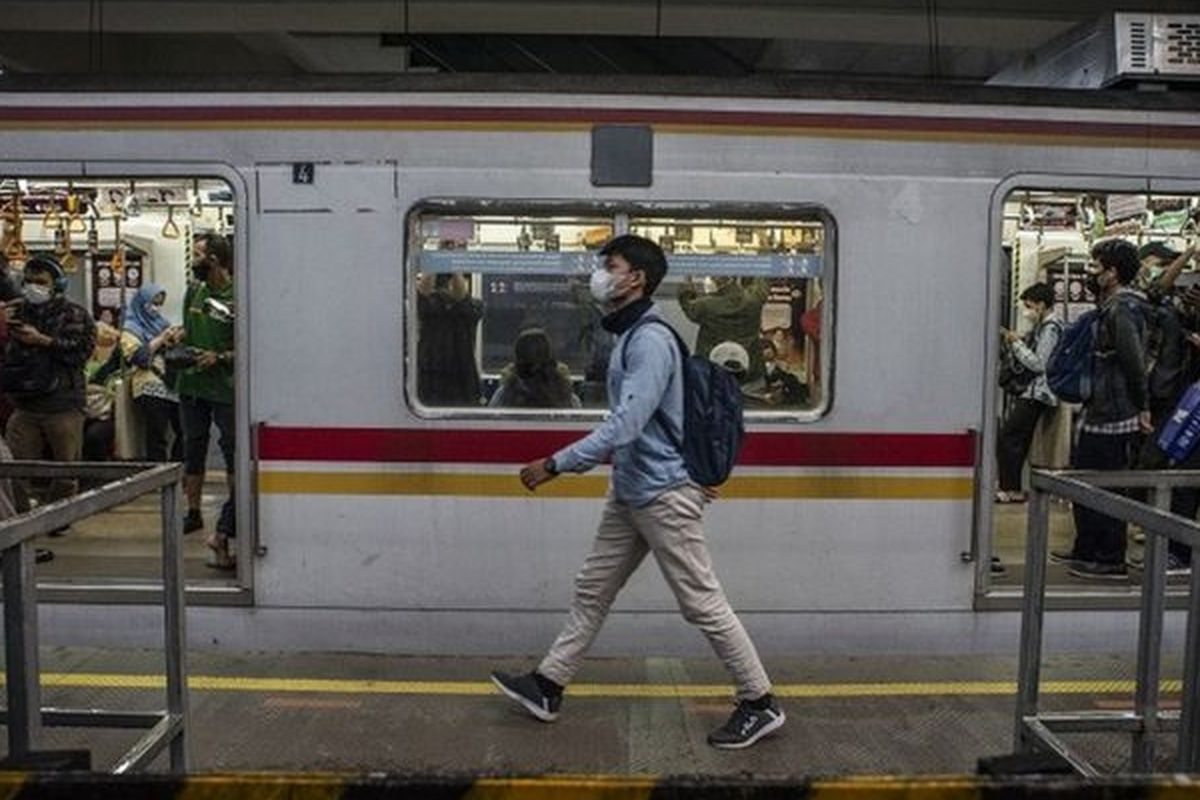 Seorang warga yang mengenakan masker melenggang di depan rangkaian kereta rel listrik (KRL) di Stasiun Manggarai, Jakarta, Kamis (06/05).