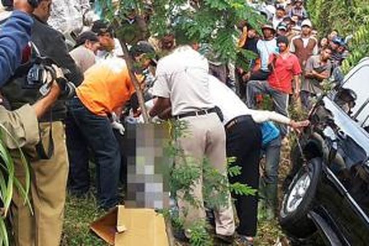 Polisi mengevakuasi mayat pria yang terjepit ban belakang Toyota Land Cruiser Cygnus di depan pintu keluar Jatim Park 2, Kota Batu, Selasa (15/7/2014).