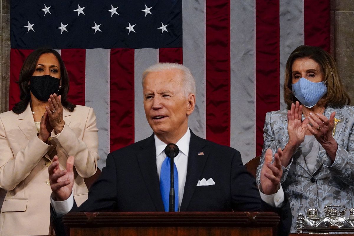 Presiden Amerika Serikat (AS) Joe Biden saat memberikan pidato di depan Kongres di Gedung Capitol, Washington DC, pada 28 April 2021. Berdiri di belakangnya adalah Wakil Presiden Kamala Harris (kiri) dan Ketua House of Representatives Nancy Pelosi.