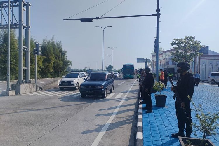LANCAR-Aparat Polres Madiun mengatur arus lalu lintas di simpang empat dumpil  tak jauh dari gerbang tol Madiun, Jumat (6/5/2022).