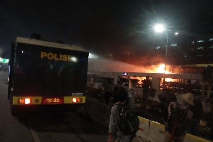 Pintu tol Pejompongan, Jalan Tol S. Parman, Selasa (24/9/2019), dibakar massa. Polisi menerjunkan kendaraan water canon untuk memadamkan api. 