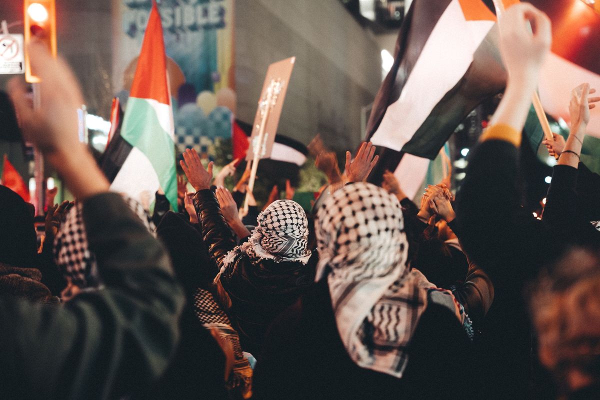 Ilustrasi demonstran dalam aksi pro-Palestina mengenakan keffiyeh.