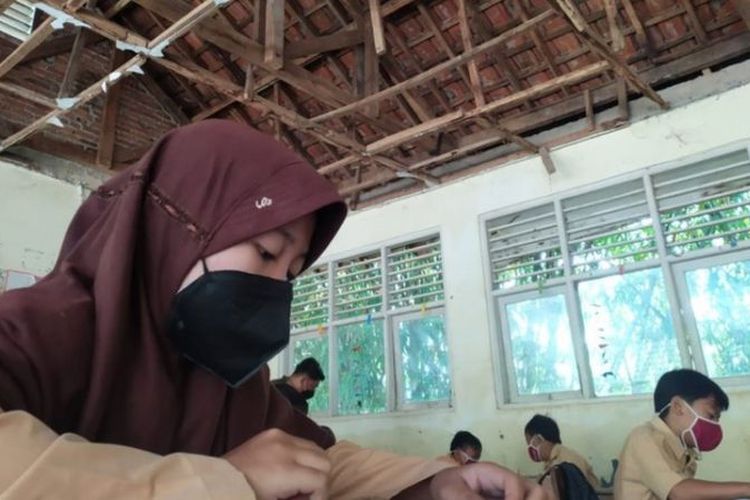 Seorang siswa SDN Jampang 02 sedang belajar di kelas yang rusak.