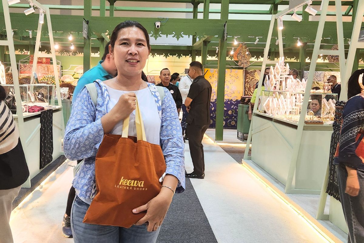 Oshien, pengunjung KKI 2026, yang menyempatkan diri untuk berbelanja sepatu dari Keewa, produk UMKM asal Yogyakarta.