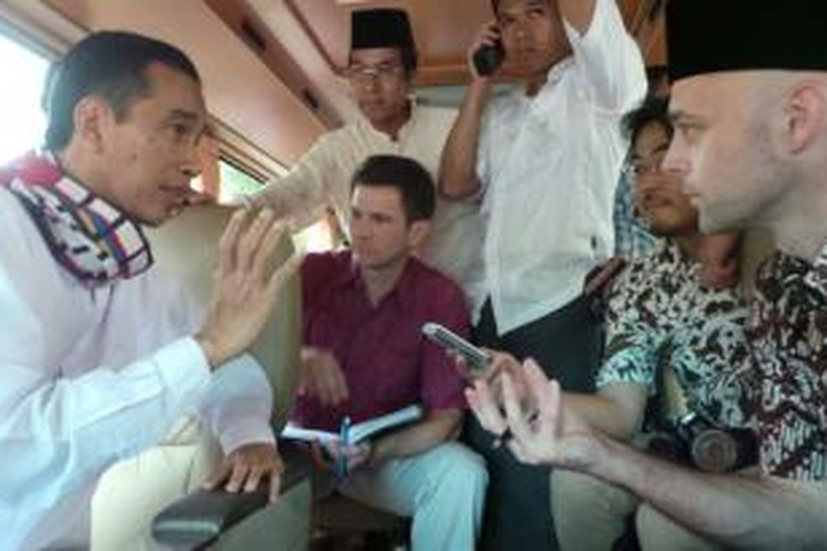 Gubernur DKI Jakarta Joko Widodo (kiri) dikelilingi wartawan media negara asing yang mewawancarainya dalam perjalanan menuju Koja, Jakarta Utara, Jumat (7/2/2014).
