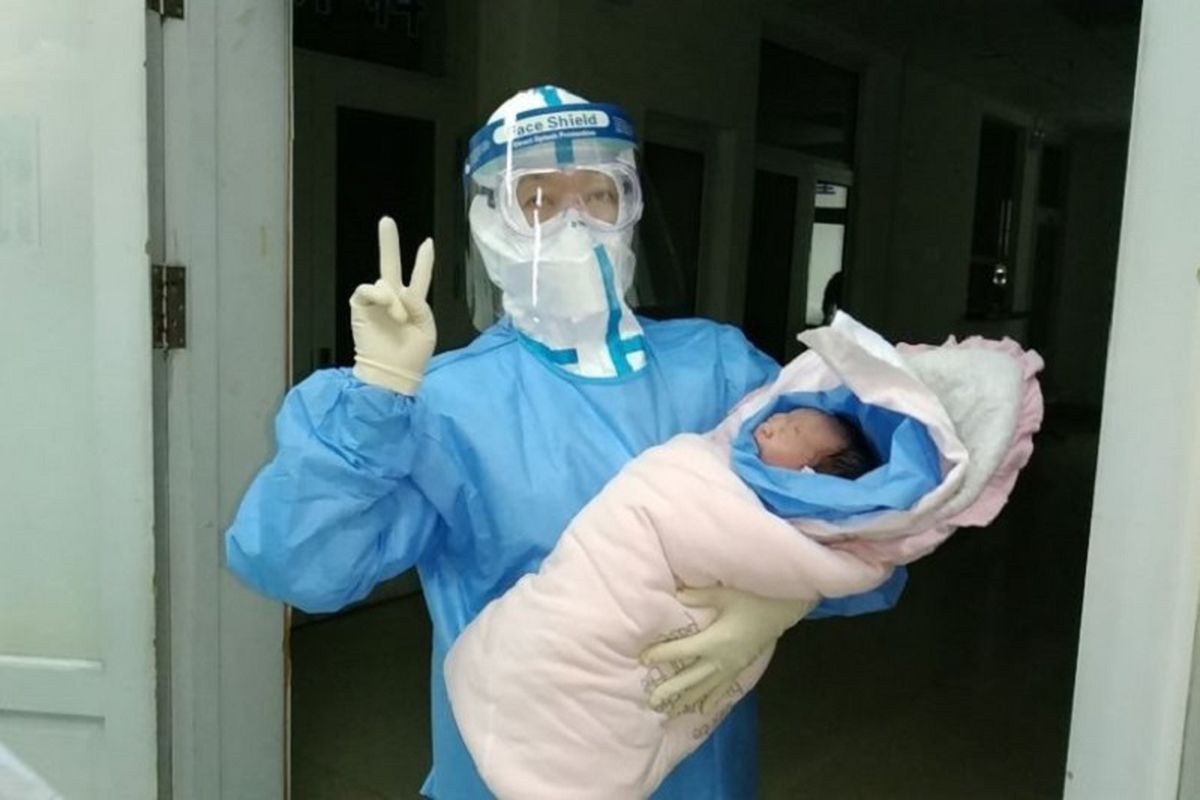 Dokter dari Rumah Sakit Nomor 6 Harbin, China, menggendong bayi yang lahir secara caesar dari ibu yang positif terkena virus corona.
