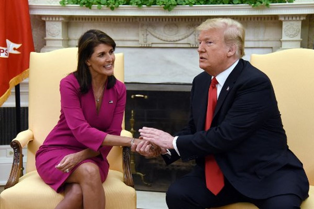 Dalam foto file yang diambil pada 09 Oktober 2018 ini, Presiden AS Donald Trump berjabat tangan dengan Nikki Haley, Duta Besar Amerika Serikat untuk PBB, di kantor Oval Gedung Putih. Mantan Presiden AS Donald Trump mengatakan pada Sabtu (18/3/2023), dirinya akan kemungkinan akan ditangkap pada Selasa (21/3/2023) terkait kasus pemberian uang suap kepada aktris film dewasa Stormy Daniels sebelum pemilu 2016.