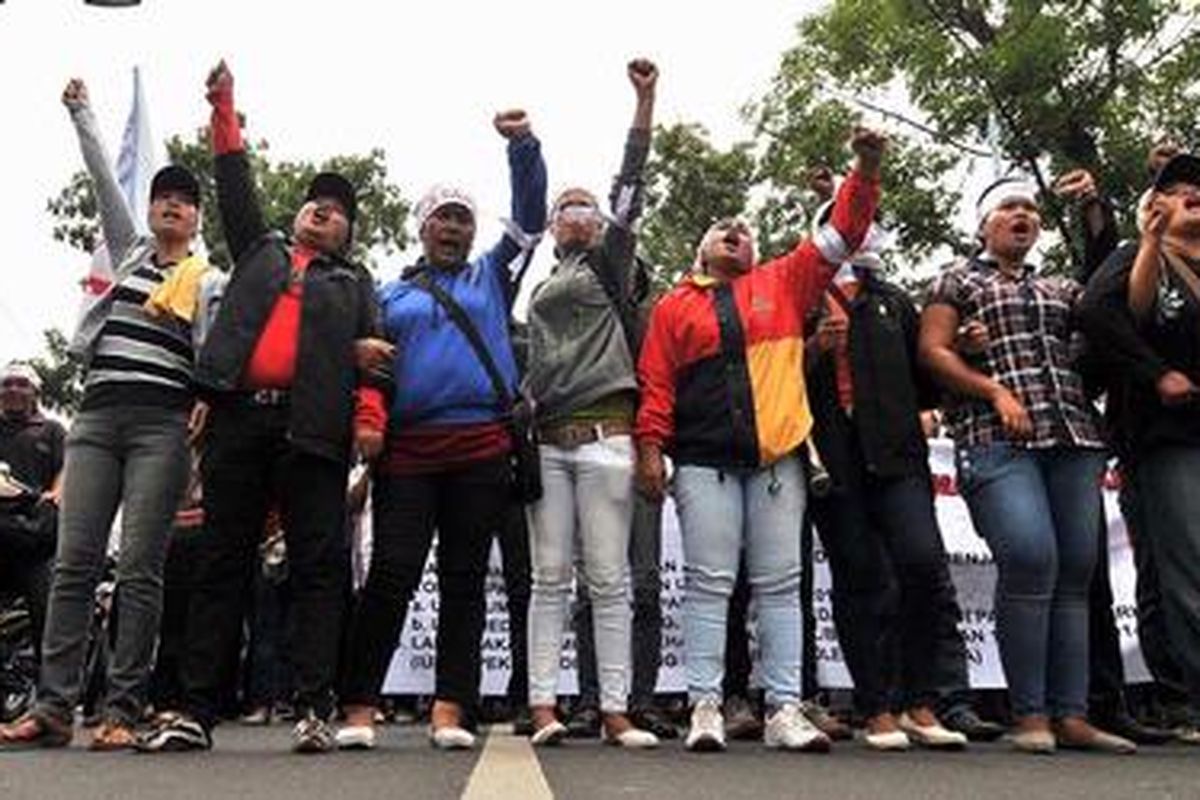 Buruh yang tergabung dalam Federasi Serikat Pekerja Metal Indonesia Sumatera Utara berunjuk rasa di Kantor Gubernur Sumatera Utara, Rabu (3/10/2012). Mereka menuntut kenaikan upah dan penghapusan sistem kerja alih daya (outsourcing). Kompas/Mohammad Hilmi Faiq  