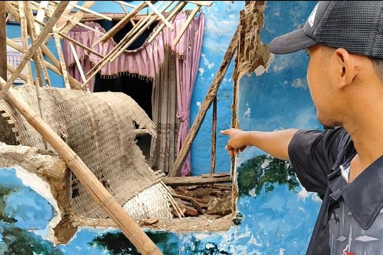 Syafiudin sedang menunjukkan rumahnya yang ambrol dan bayinya selamat setelah sempat tertimbun reruntuhan atap, Selasa (17/12/2024) 