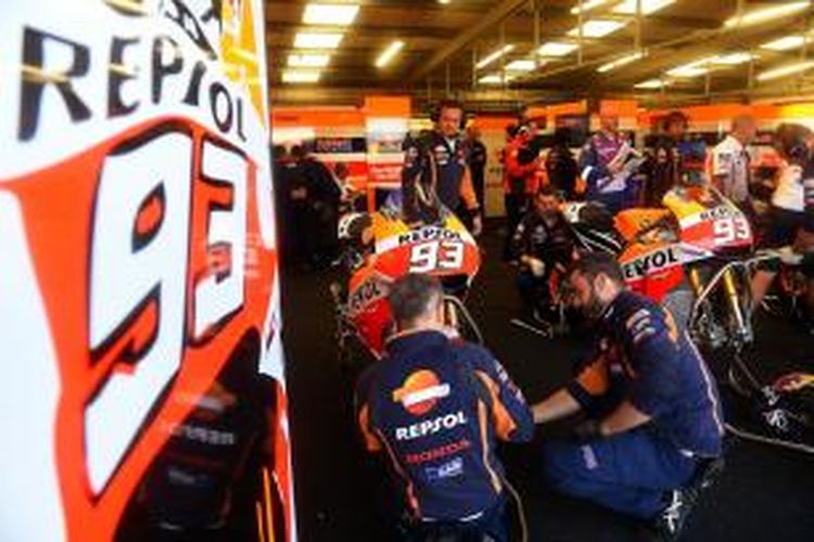 Kru Repsol Honda tengah mempersiapkan motor yang akan dipakai Marc Marquez untuk sesi latihan bebas kedua GP Inggris di Sirkuit Silverstone, Jumat (28/8/2015).