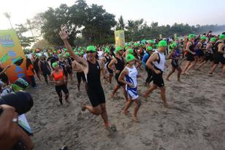 Peserta Herbalife Bali International Triathlon (HBIT) 2015 berlari melakukan start untuk melakukan sesi renang di kawasan Pantai Jimbaran, Bali, Minggu (25/10/2015).