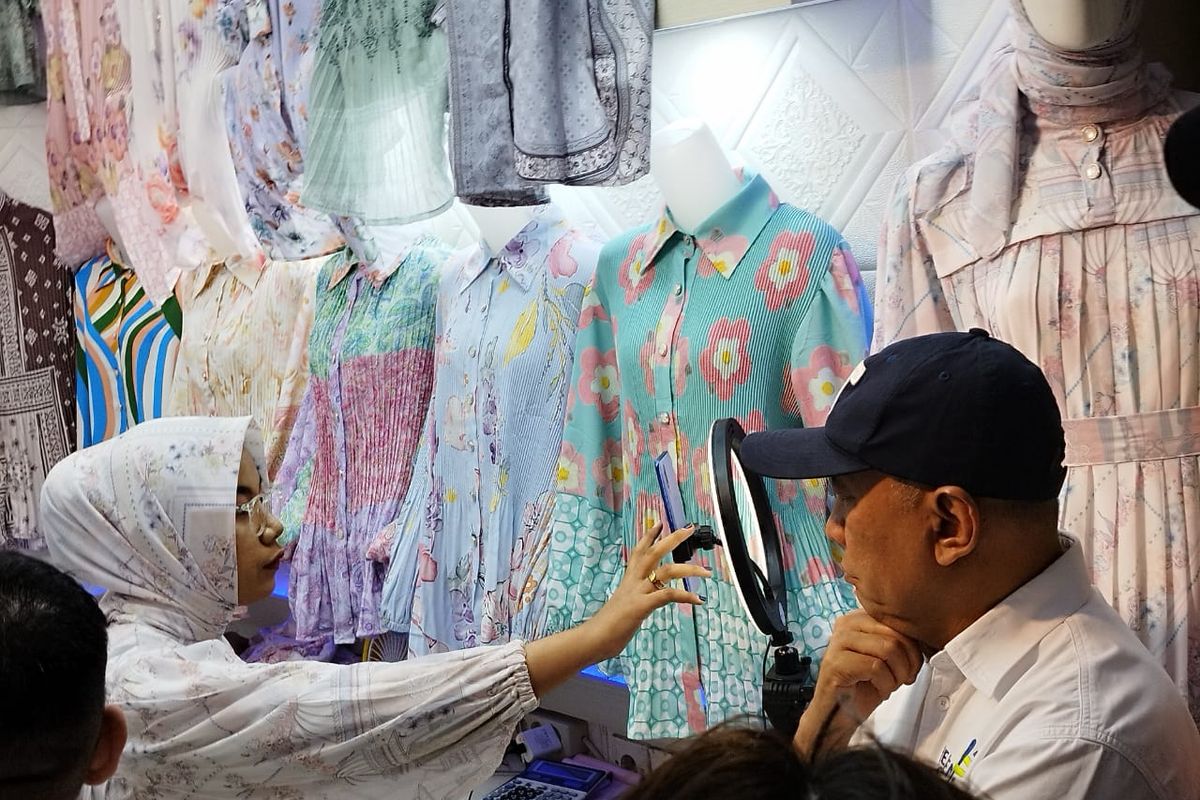 Menkop UKM Teten Masduki memerhatikan pedagang yang sedang melakukan siaran langsung untuk berjualan produk miliknya di Pasar Tanah Abang Blok A, Jakarta Pusat, Selasa (19/9/2023).