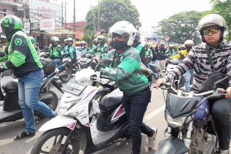 Aksi menuntun motor para pengemudi ojek online di Kota Serang, Banten. Mereka menyampaikan aspirasi di depan Kantor Gubernur Banten