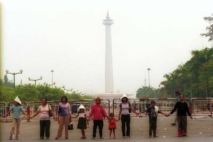 Sejumlah orang bergandengan tangan bersama dengan ribuan warga DKI Jakarta lainnya. Mereka bergabung untuk membuat pagar manusia di sepanjang pelataran Monumen Nasional (Monas), Jakarta Pusat, Minggu (29/9/2002), untuk menolak upaya Pemerintah Provinsi (Pemprov) DKI Jakarta membuat pagar yang mengelilingi Monas, karena tempat tersebut merupakan ruang publik yang tidak perlu dipagari. 