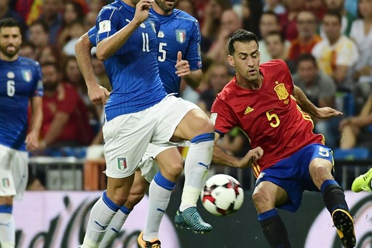 Gelandang Spanyol, Sergio Busquets (kanan), berebut bola dengan bek Italia, Daniele Rugani (2 dari kanan) dam striker Ciro Immobile dalam pertandingan Kualifikasi Piala Dunia 2018 di Stadion Santiago Bernabeu, 2 September 2017.
