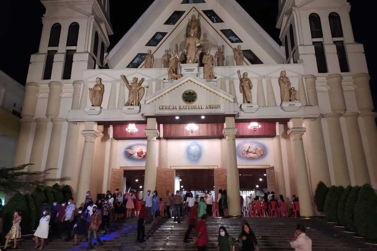 Umat Katolik di Ambon keluar dari pintu gereja Katedral Fransiskus Xaverius usai mengikuti Misa Natal, Kamis malam, (24/12/2020)