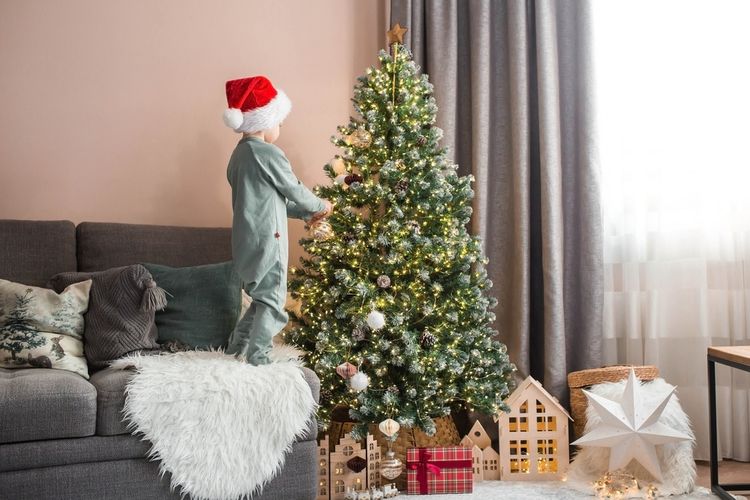 Ilustrasi pohon natal di ruang tamu sempit. 