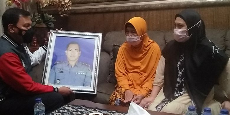Murhaleni (wearing orange headscarf) who is the mother of Lieutenant Colonel Heri Oktavian, the commander of Indonesia's KRI Nanggala 402 submarine fleet, speaks to a spokesperson for Lampung Police on Saturday, April 24, 2021.   