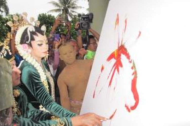 Pasangan seniman Wawan Geni dan Putri melukis bersama di upacara pernikahannya di Museum H. Widayat, Magelang, Minggu (8/3/2015).