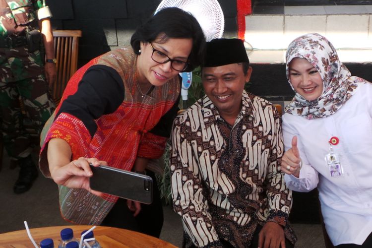 Menteri Keuangan Sri Mulyani berswafoto dengan Kepala Desa Ponggok Junaedhi Mulyono dan Pelaksana Tugas (Plt) Bupati Klaten Sri Mulyani, di Umbul Ponggok, Klaten, Rabu (23/8/2017).