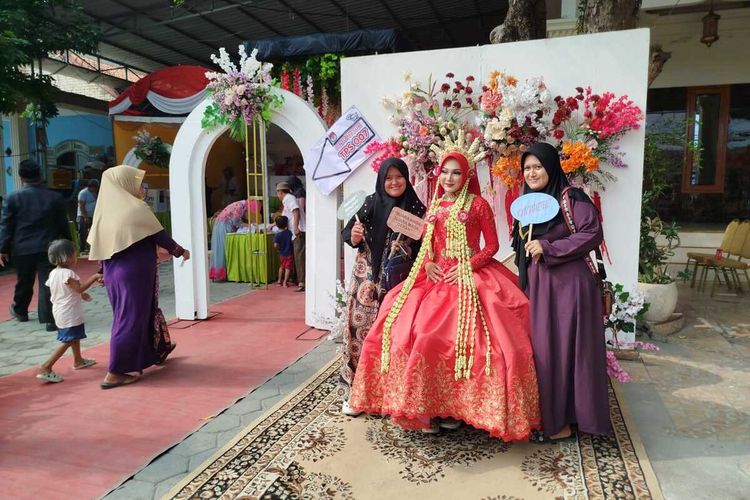 Pemilih TPS 007 Dusun Ketengan, Desa Tanjung, Kecamatan Burneh, Kabupaten Bangkalan, Jawa Timur, berfoto dengan pengantin setelah memberikan hak suaranya pada Pilkada Kabupaten Bangkalan.