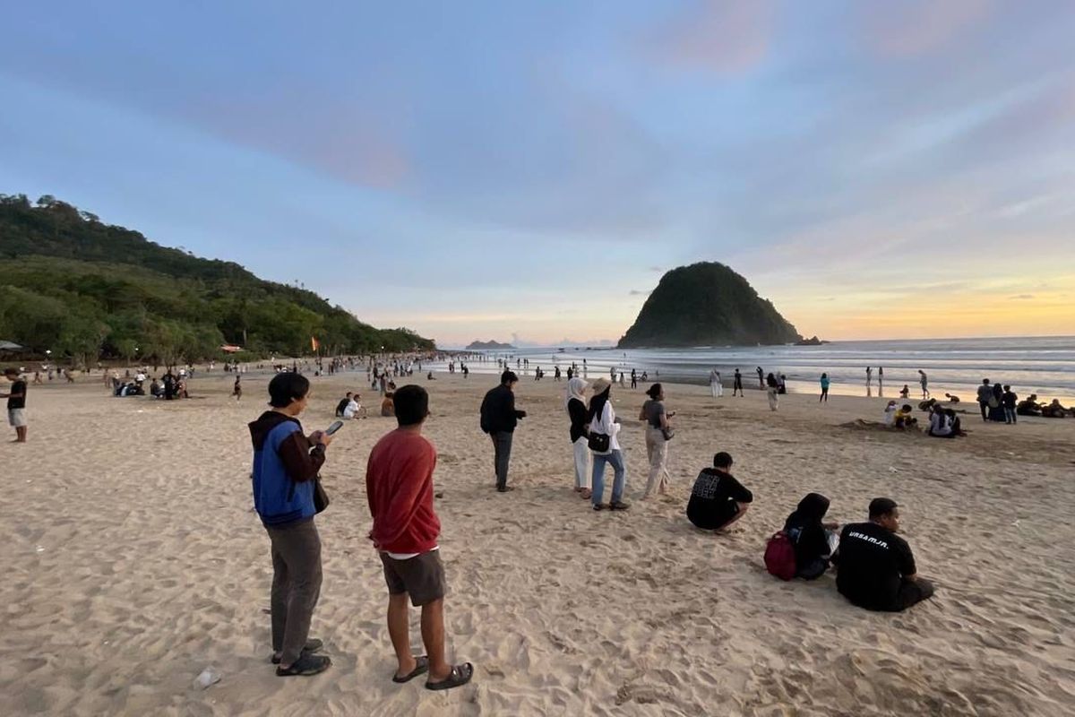 Wisatawan mengunjungi Pantai Pulau Merah di Pesanggaran Banyuwangi saat momen libur Lebaran. 