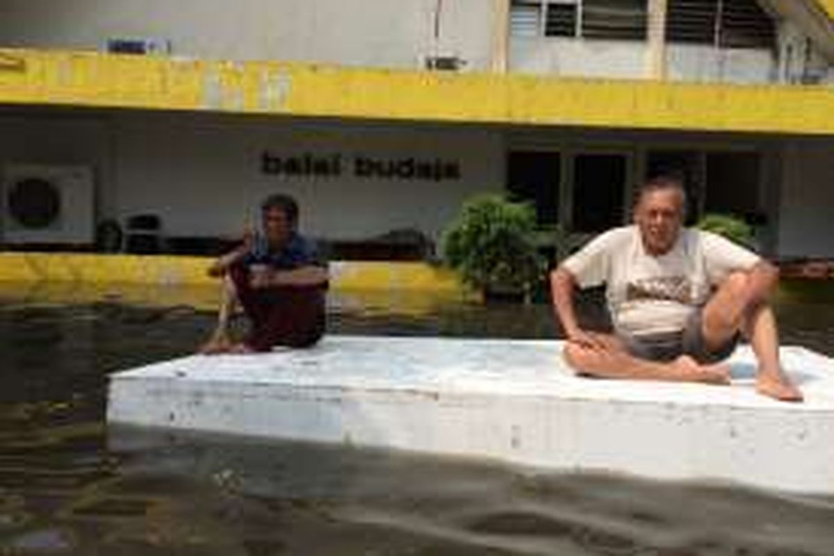 Dari kiri, Syahnagra Ismaill (63) dan Sudita Nashar (54), duduk di atas getek di halaman Balai Budaya, Gondangdia, Menteng, Jakarta Pusat, Selasa (30/8/2016). Balai Budaya digenangi air setinggi 60 sentimeter usai diguyur hujan selama satu jam lebih pada siang tadi.