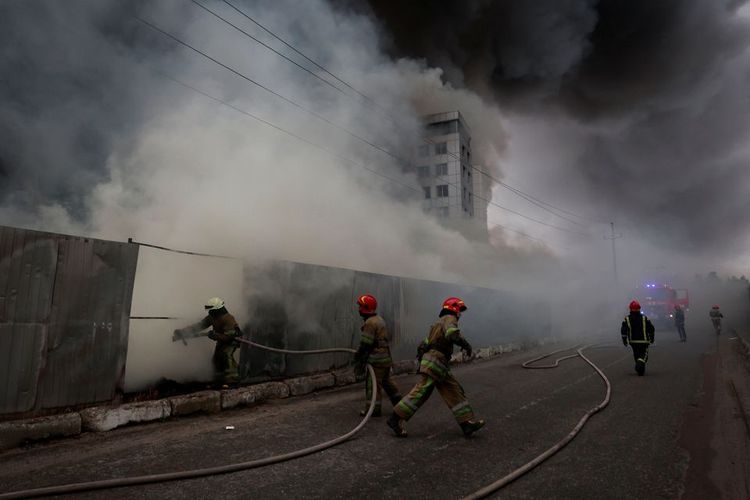 Petugas pemadam kebakaran memadamkan api di sebuah gudang yang terbakar setelah penembakan, saat invasi Rusia ke Ukraina berlanjut, di desa Chaiky di wilayah Kyiv, Ukraina, Kamis (3/3/2022). 