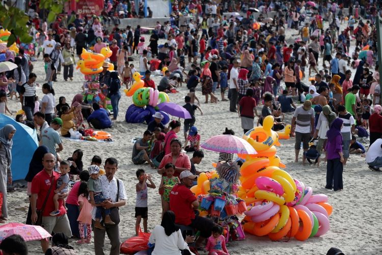 Pengunjung memanfaatkan liburan mengunjungi pantai di kawasan Taman Impian Jaya Ancol, Jakarta, Selasa (27/6/2017). Sejumlah lokasi wisata di Jakarta padat pengunjung pada libur lebaran. 