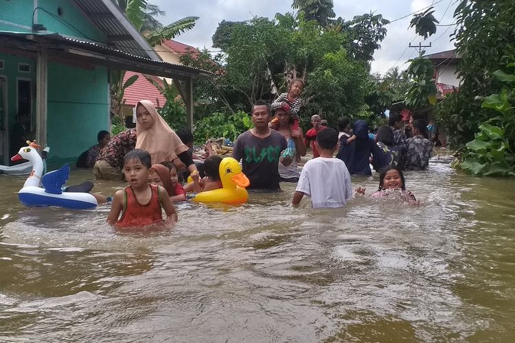 Warga mandi dan bermain air di lokasi banjir di Desa Pulau Rambai, Kecamatan Kampa, Kabupaten Kampar, Riau, Minggu (15/12/2019) sore.