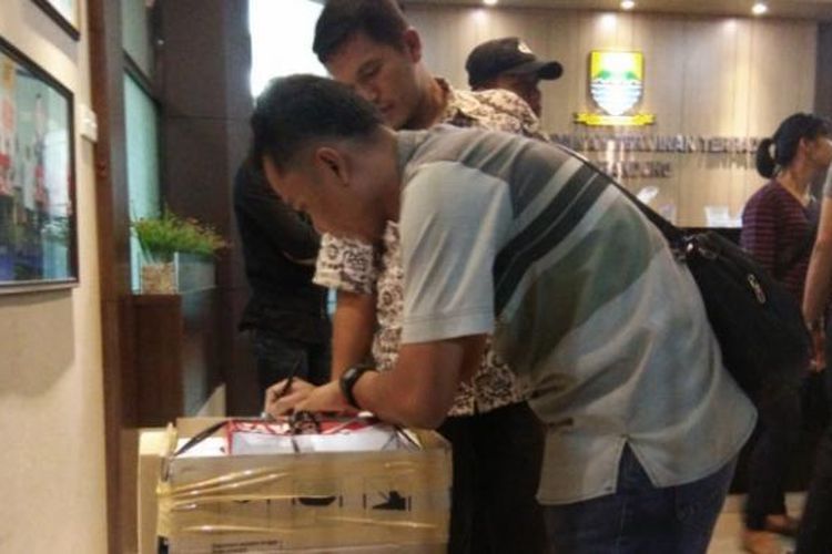 Anggota Polrestabes Bandung saat mengamankan barang bukti hasil penangkapan Kepala Dinas Penanaman Modal dan Pelayanan Terpadu Satu Pintu (DPMPTSP) Dandan Riza Wardana, Jumat (27/1/2017) malam.  