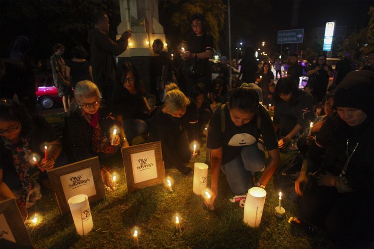 Warga menyalakan lilin dan berdoa bersama untuk korban bom gereja di Surabaya dalam aksi solidaritas di Solo, Jawa Tengah, Minggu (13/5/2018).