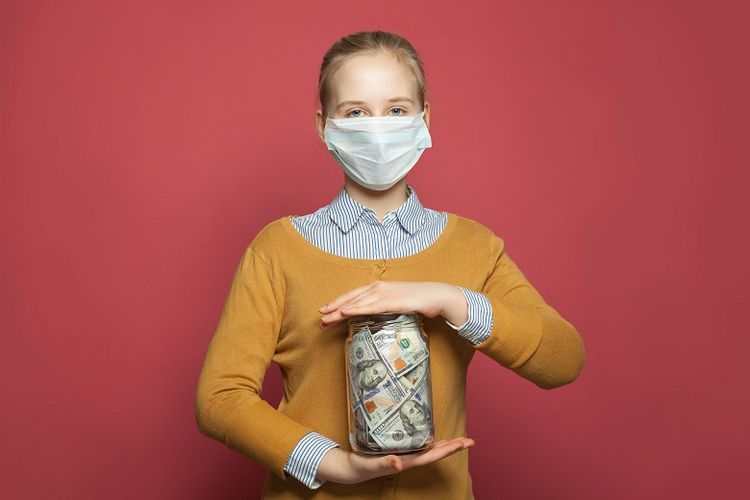 Girl in medical mask holding money cash us dollars on blue background