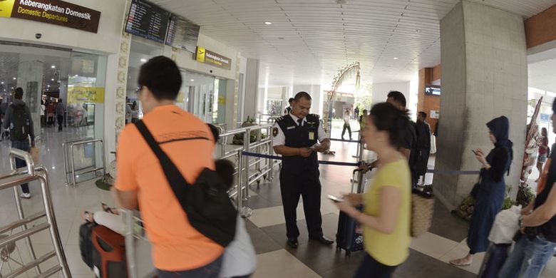 Petugas memeriksa tiket calon penumpang pesawat di Terminal Keberangkatan Domestik Bandara Internasional I Gusti Ngurah Rai, Bali, Jumat (4/1/2019).  