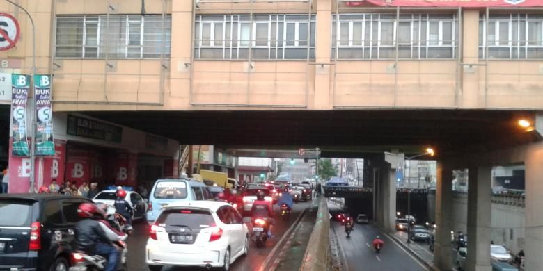 Lalu lintas di bawah jembatan penghubung Pasar Tanah Abang, Jakarta Pusat, yang lebih tertib, Senin (22/7/2013). Mulai hari ini, kendaraan yang dari arah Pejompongan (selatan) hendak menuju Cideng (utara) maupun sebaliknya, wajib melewati terowongan Tanah Abang. Adapun jalur jalan KH Mas Mansyur hanya diperuntukan bagi kendaraan yang hendak berbelanja dengan belok kiri ke arah Jalan Kebon Jati, ataupun  kendaraan yang hendak putar balik ke arah kanan menuju kawasan Bundaran HI