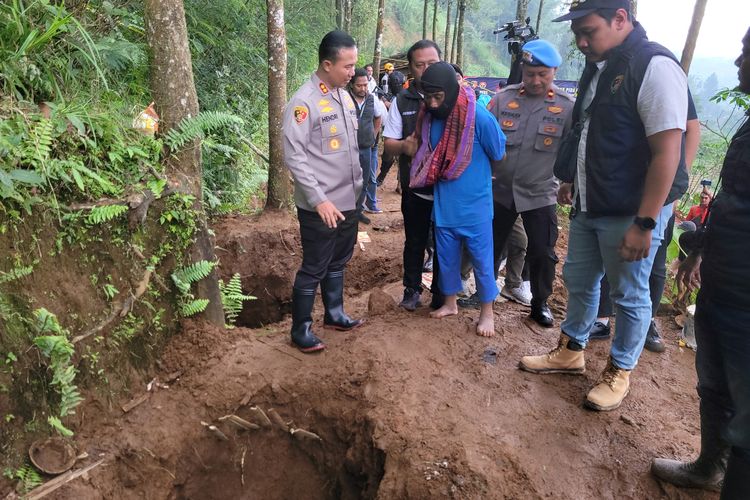 Tersangka dukun pengganda uang Tohari (45) alias Mbah Slamet diminta menuunjukkan lokasi kuburan du lahan miliknya di Desa Balun, Kecamatan Wanayasa, Banjarnegara, Jawa Tengah, Selasa (4/4/2023). 