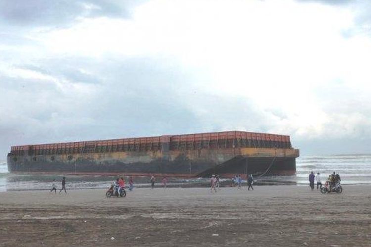 Sebuah kapal tongkang terdampar di kawasan wisata Pantai Jetis Cilacap, Minggu (26/5/2022). Kapal tongkang terdampar setelah dihantam ombak besar. 