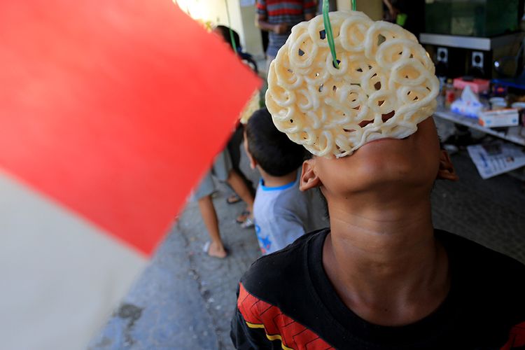 Sejumlah anak mengikuti lomba makan kerupuk untuk memeriahkan HUT Ke-76 Kemerdekaan Republik Indonesia di Desa Lamteumen Timur, Jaya Baru, Banda Aceh, Aceh, Selasa (17/8/2021). Berbagai perlombaan dalam memeriahkan HUT Kemerdekaan RI tahun ini dilakukan secara sederhana dan dengan protokol kesehatan untuk mencegah penularan dan penyebaran Covid-19.