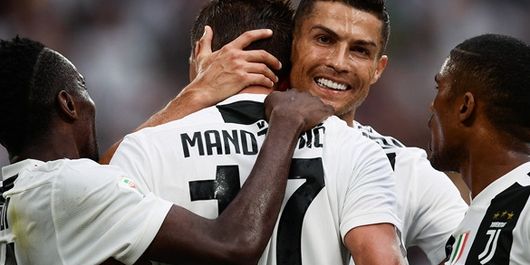 Megabintang Juventus, Cristiano Ronaldo (kedua dari kanan), memeluk Mario Mandzukic yang mencetak gol ke gawang Lazio dalam laga Liga Italia di Allianz Stadium, Turin pada 25 Agustus 2018.
