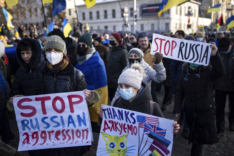 Demonstran dengan bendera dan poster nasional Ukraina berbaris di pusat Kharkiv, kota terbesar kedua di Ukraina, Sabtu, 5 Februari 2022, hanya 40 kilometer (25 mil) dari beberapa dari puluhan ribu tentara Rusia yang berkumpul di perbatasan Ukraina. 