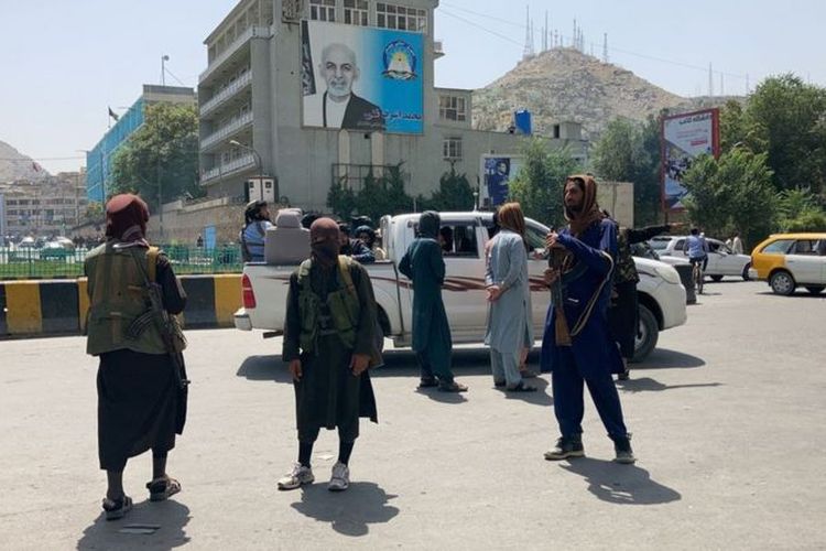 Milisi Taliban yang bersiaga di jalanan menenteng senjata.