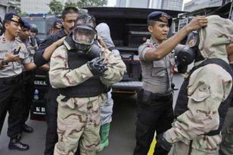 Anggota polisi penjinak bom mengenakan alat pelindung sebelum memeriksa lokasi ledakan yang menghantam kawasan Jalan MH Thamrin, Jakarta Pusat, 14 Januari 2016. Serangkaian ledakan menewaskan sejumlah orang, terjadi baku tembak antara polisi dan beberapa orang yang diduga pelaku.